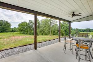 a porch with a table and chairs and a ceiling fan at Burkesville Cabin, 3 Mi to Dale Hollow Lake! in Frogue