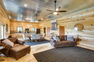 a living room with two leather couches and a kitchen at Burkesville Cabin, 3 Mi to Dale Hollow Lake! in Frogue