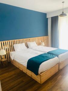 OmaloにあるPark Hotel Tushetiの青い壁のベッドルーム1室(大型ベッド1台付)