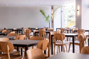 ein Esszimmer mit Tischen und Stühlen und einem großen Fenster in der Unterkunft Island City Hotel in Rhodos (Stadt)