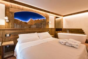 ein Schlafzimmer mit einem Bett und einer Badewanne in einem Zimmer in der Unterkunft Le Moulin Des Aravis in Pontboset