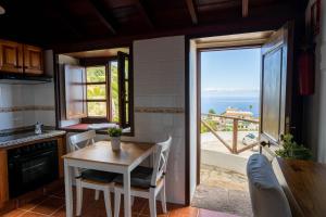 a kitchen with a table and a view of the ocean at LAS CASITAS DEL BEBEDERO - Yoga & Ecoturismo in Icod de los Vinos