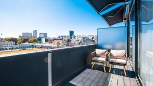 d'un balcon avec deux chaises et vue sur la ville. dans l'établissement Hills Hotel Lisboa, à Lisbonne