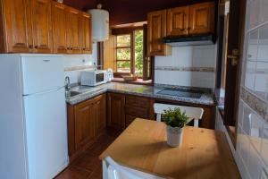 uma cozinha com uma mesa de madeira e um frigorífico branco em LAS CASITAS DEL BEBEDERO - Yoga & Ecoturismo em Icod de los Vinos