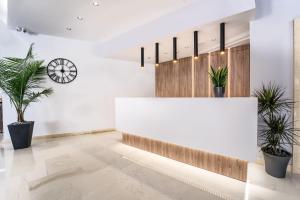 a lobby with a white counter and potted plants at Island City Boutique Hotel in Rhodes Town