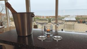 tres copas de vino sentadas en un mostrador con un cubo en Panorama udsigt og pool, en Ålsgårde
