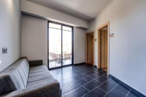 a living room with a couch and a balcony at Island City Boutique Hotel in Rhodes Town