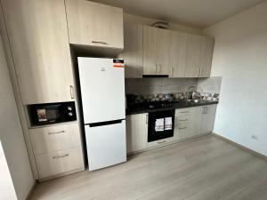a kitchen with a white refrigerator in a room at Apartment, Podillya in Vinnytsya