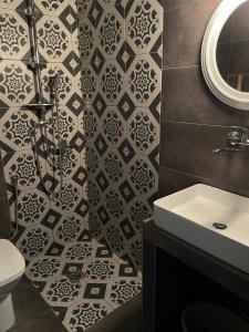 a bathroom with a black and white tile wall at Xenios Hotel in Pefkochori