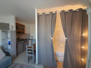 a room with a curtain in a room with a kitchen at Romance à 70 m de la plage in Royan