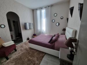 a bedroom with a purple bed and a window at BARREAU in Libourne
