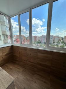 a room with windows with a view of the city at Apartment, Podillya in Vinnytsya