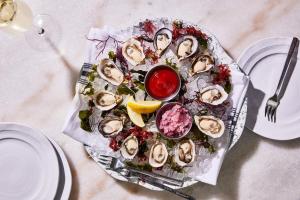 a platter of oysters on a plate on a table at Kimpton Sawyer Hotel by IHG in Sacramento