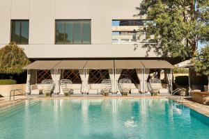 a swimming pool with chairs and a building at Kimpton Sawyer Hotel by IHG in Sacramento +100 photos