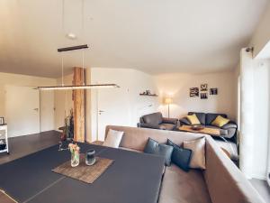 ein Wohnzimmer mit einem Sofa und einem Tisch in der Unterkunft FEWO Morgenröte - Weserblick -Harriersand in Schwanewede
