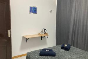 帕皮提的住宿－"Frangipani" city center room，卧室配有两张床和一张墙上的桌子。