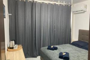 ein Schlafzimmer mit 2 Betten und einem grauen Vorhang in der Unterkunft "Frangipani" city center room in Papeete