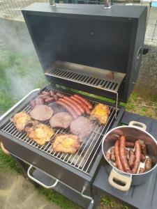 a grill with meat and sausages and a pan at Apartment Vanda in Matulji
