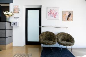 two chairs sitting on a rug in a room at Joondalup City Hotel in Perth