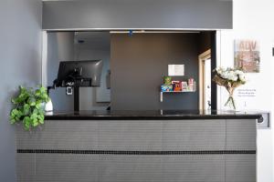 a kitchen with a black counter top and a counter top at Joondalup City Hotel in Perth