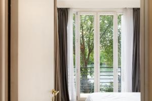 1 Schlafzimmer mit einem Fenster mit Blick auf einen Balkon in der Unterkunft Magnifique appartement avec une très belle vue sur seine in Boulogne-Billancourt