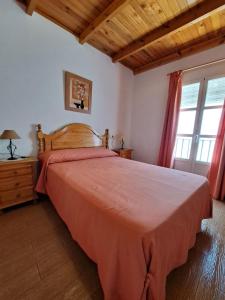 um quarto com uma cama grande e uma colcha vermelha em CASA ELBA em Gaucín