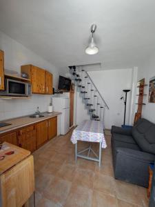 uma cozinha e sala de estar com um sofá e uma mesa em CASA ELBA em Gaucín