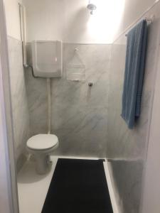 a small bathroom with a toilet and a blue towel at Pousada 714 in Brasília