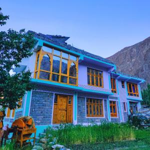 ein blaues Haus mit einem Berg im Hintergrund in der Unterkunft Sukoon Turtuk Home Stay in Turtok