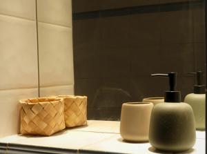 a bathroom counter with two soap dispensers and a mirror at Chambre d'hôtes in Lançon-Provence