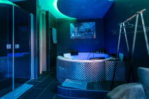 y baño azul con bañera y ducha. en Hotel Platin en Regensburg