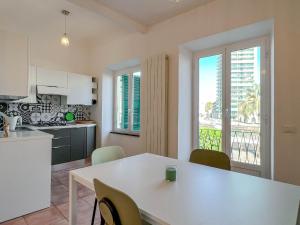 een keuken en eetkamer met een witte tafel en stoelen bij Bilocale fronte Porto Antico in Savona