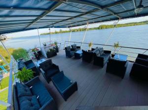 a deck with couches and chairs on a boat at Hotel Plutitor Egreta1 in Sfântu Gheorghe