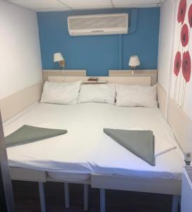 un grande letto bianco in una stanza con pareti blu di Hotel Plutitor Egreta1 a Sfântu Gheorghe