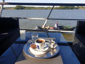 a cup of coffee and cookies on a table on a boat at Hotel Plutitor Egreta1 in Sfântu Gheorghe