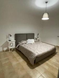 una camera da letto con un letto con due tavoli e una lampada di Casa Rocca di Cambio a Rocca di Cambio