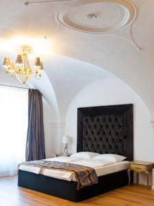 a bedroom with a large bed and a chandelier at Sia Boutique Aparthotel in Sibiu