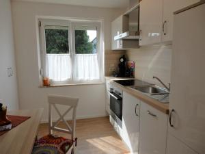 a small kitchen with a sink and a window at Ferienwohnung Stiefel mit Garage & AusZeit Card in Wangen im Allgäu