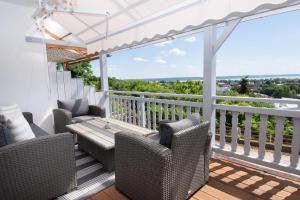 a porch with wicker chairs and a table on a balcony at Panorama Residence in Balatonalmádi