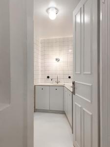 a white bathroom with a sink and a door at Trilogy Experimental in Thessaloniki