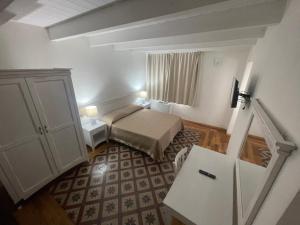 Habitación pequeña con cama y mesa en L'araucaria Le Camere, en Riola Sardo