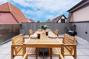 a wooden table and chairs on a patio at Fewos am Main mit Dachterrasse & Fahrradgarage - by homekeepers in Ochsenfurt