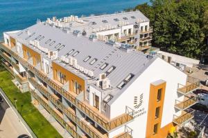 - une vue aérienne sur un bâtiment avec l'océan derrière dans l'établissement Apartment next to the beach with sea view Ustronie Morskie, à Ustronie Morskie