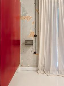 a room with a window and a white curtain at Trilogy Experimental in Thessaloniki
