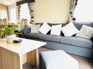 a living room with a blue couch with white pillows at Cosy Corner in Filey
