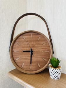 a wooden clock sitting on a shelf next to a plant at Cosy Corner in Filey