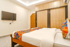 a bedroom with a bed and a flat screen tv at FabExpress RS Living in Hyderabad