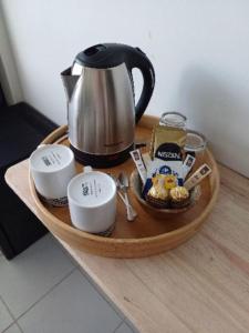 a tray with a tea kettle on top of a counter at "Hibiscus" city center room in Papeete