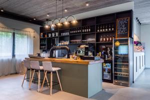 a bar with two stools at a counter in a room at Viešbutis SAKAI sodyboje Gribžė in Gribžiniai +14 photos