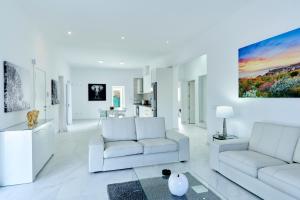 uma sala de estar com mobiliário branco e uma pintura na parede em Villa Boutique Can Bellotera em Sant Jordi
